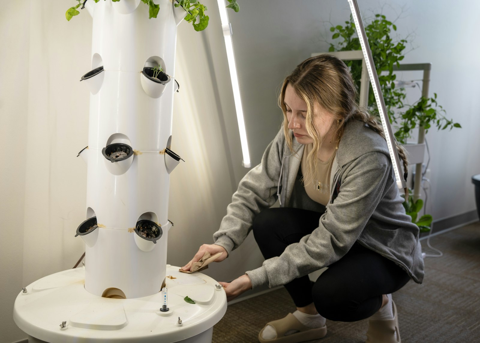 Liberty Booth, a junior, cleans up around the aeroponics garden tower before harvesting the vegetables.